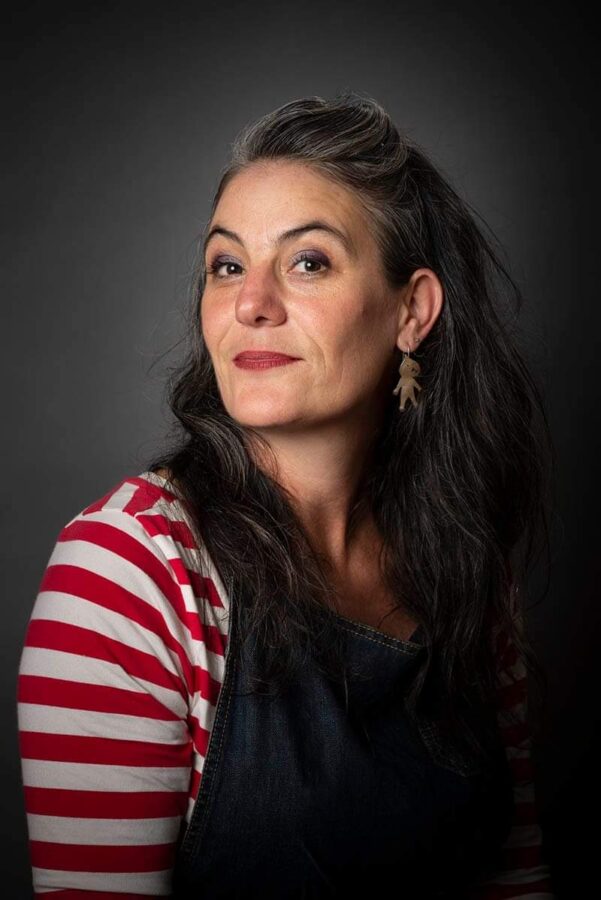 Woman with long dark hair wearing a red and white striped shirt