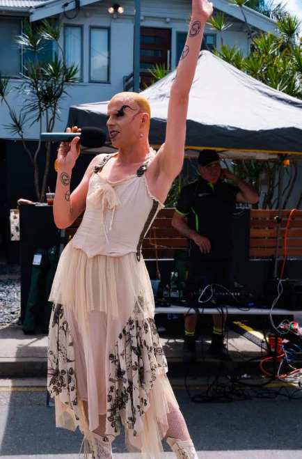 A person in a white dress with a microphone