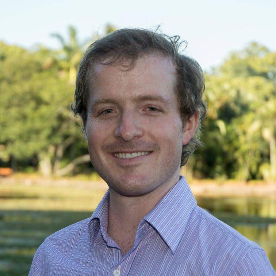 A man with short hair smiling at the camera