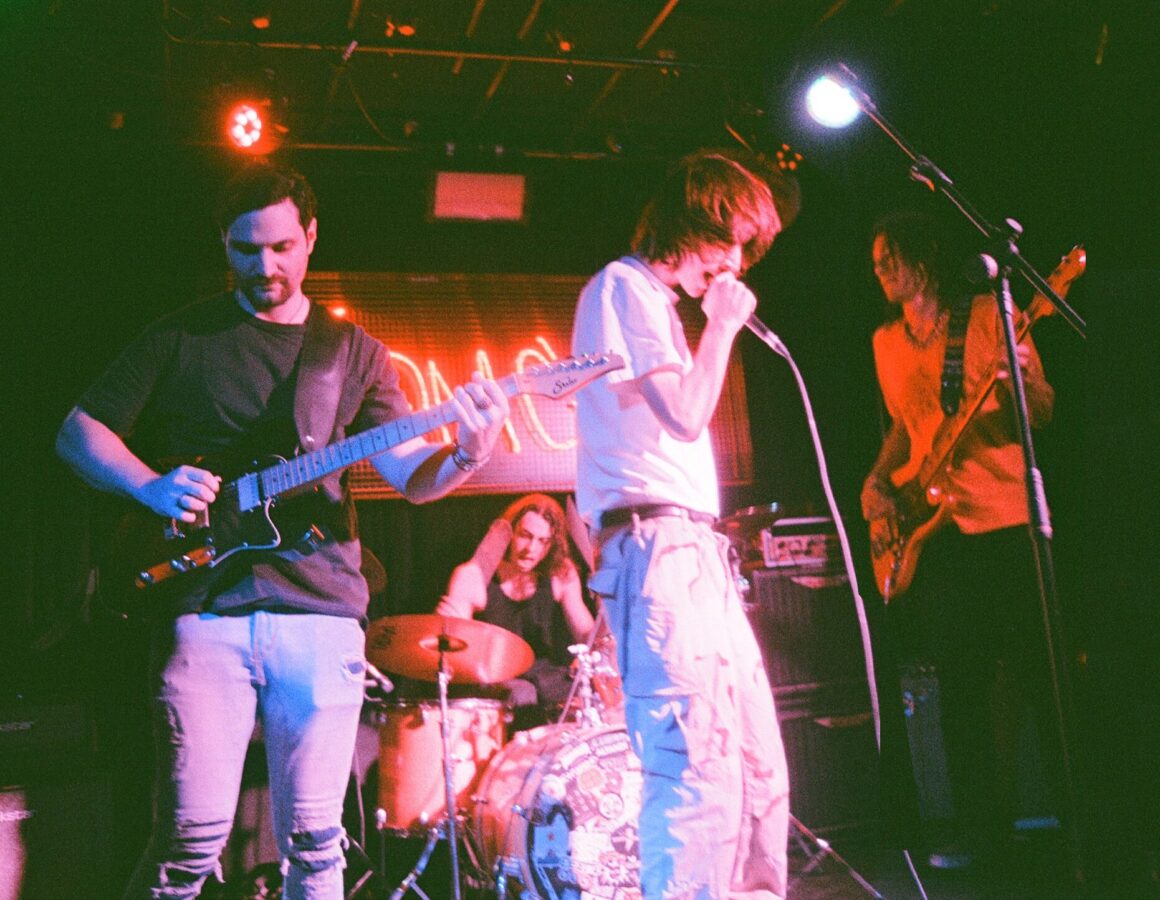 4 people playing instruments on a stage.